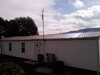New metal roof on a single wide mobile home with a TV antenna in Bucyrus